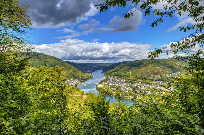 River valley with town and vineyards under cloudy sky