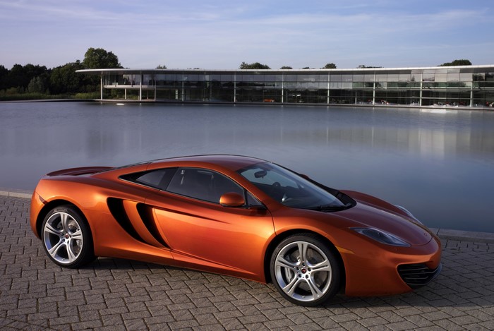 Orange McLaren MP4-12C parked by a lake