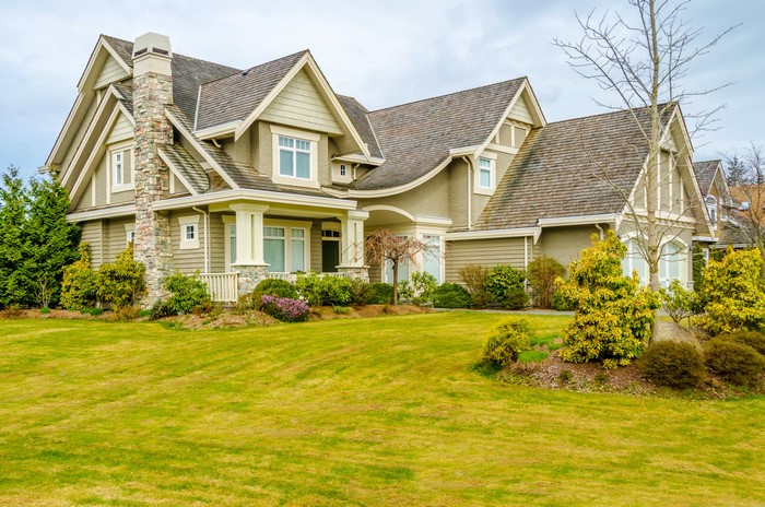 Large house with stone chimney and manicured lawn