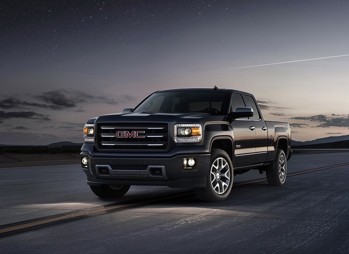 Black GMC Sierra truck on a road at night
