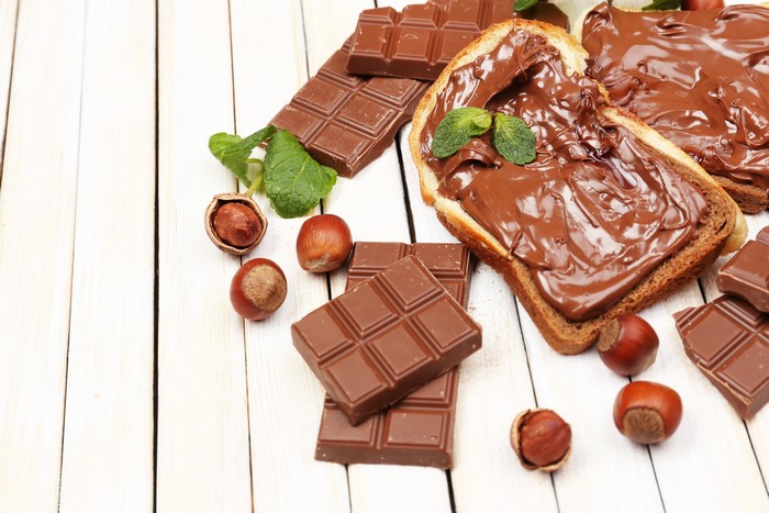 Chocolate spread on bread with hazelnuts and chocolate bars