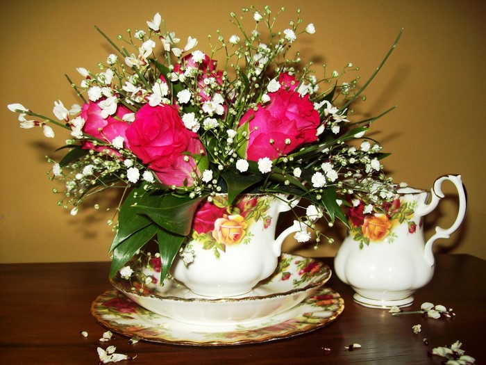 Roses in a teacup with a creamer