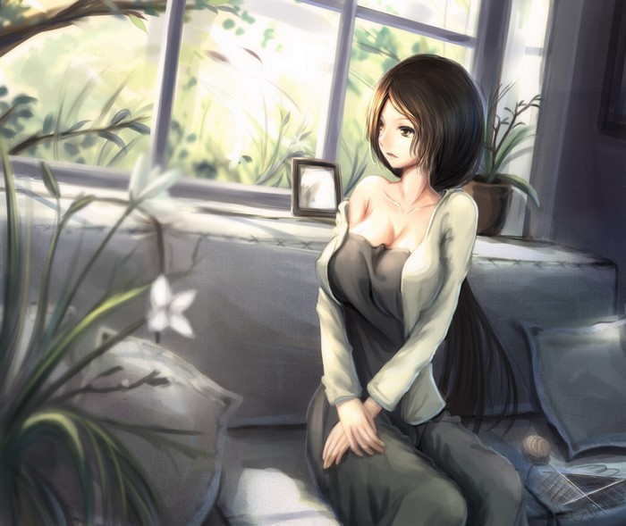 Woman sitting on a sofa by the window