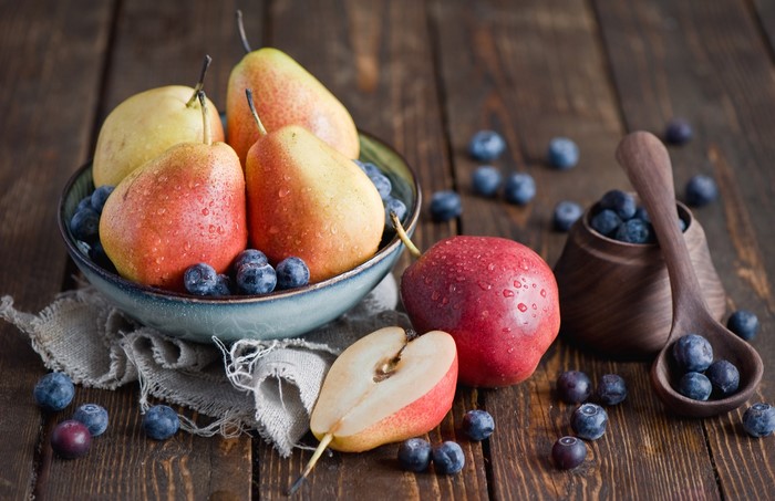 Pears and blueberries in a bowl with a spoon