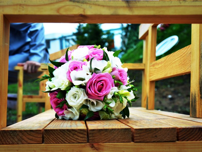 Pink and white roses bouquet on a wooden bench