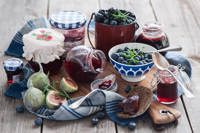Still life of jams, fruits, and berries on a wooden table