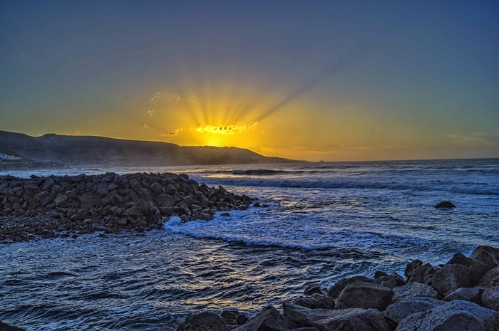 Sunset over the sea with rocky coast in Spain