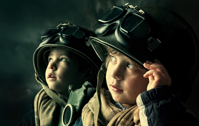 Two boys in helmets and gas masks