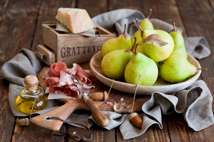 Pears, Prosciutto, Cheese, and Olive Oil on Wooden Table
