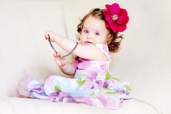 Baby girl in a floral dress with a flower in her hair