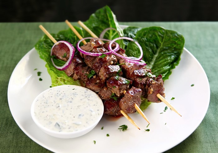 Shashlik skewers with dipping sauce on a plate