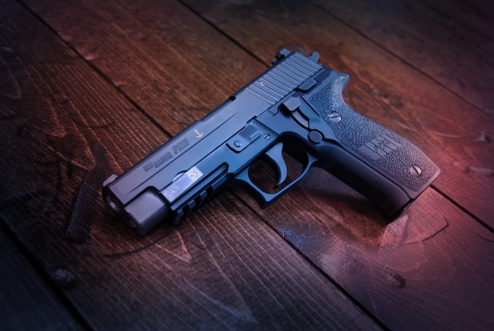 SIG-Sauer P226 pistol on wooden planks