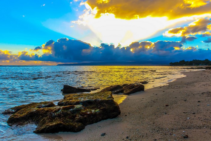 Sunset over the ocean with clouds and beach