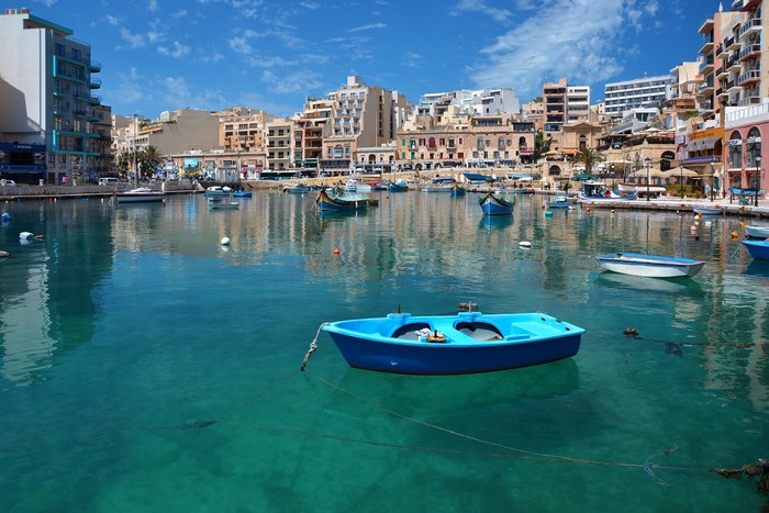 Boats in a harbor with buildings in St. Julians, Malta