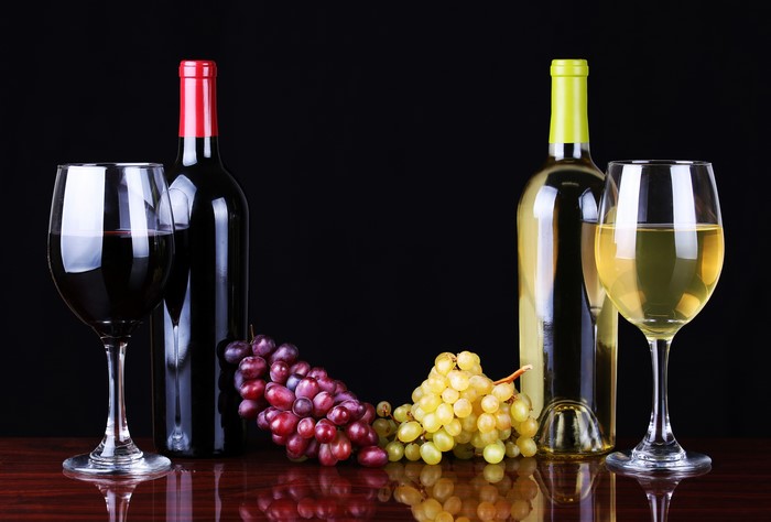 Red and White Wine Bottles with Grapes and Glasses