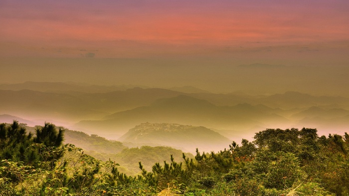 Misty Mountains with a Village at Sunset