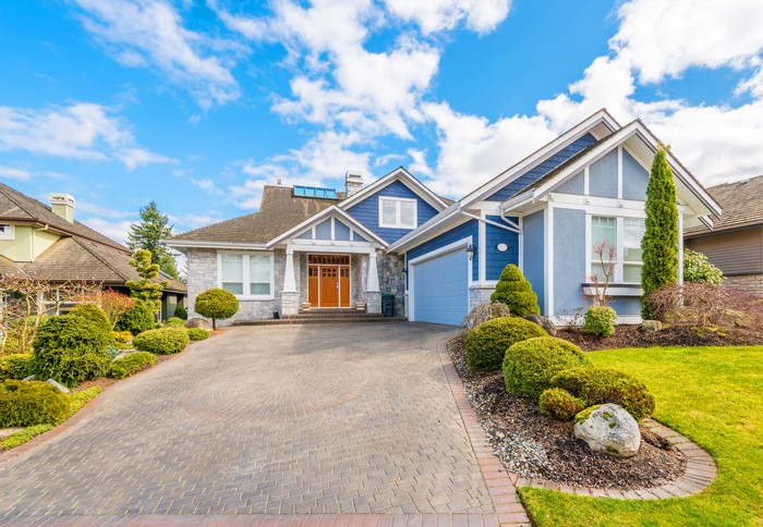 Blue house with stone accents and manicured landscaping