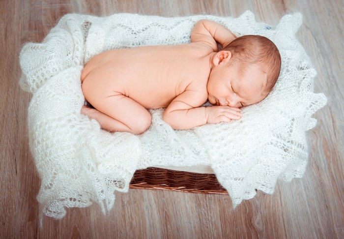 Newborn baby sleeping in a wicker basket