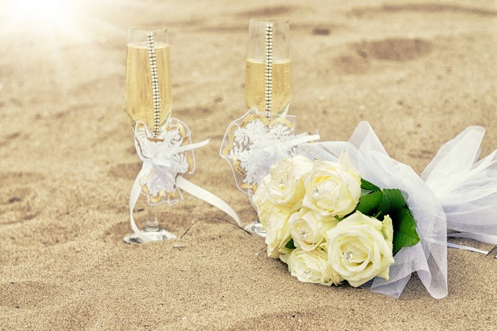 Champagne Glasses and White Roses on Sand