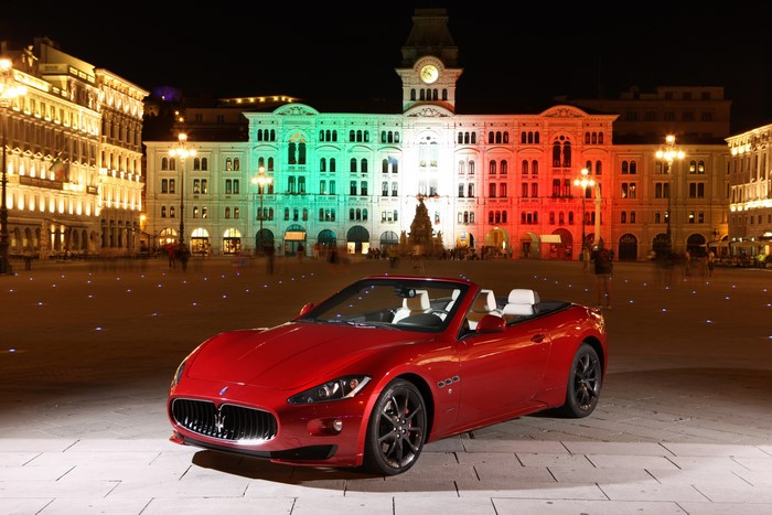Red Maserati GranCabrio Sport convertible at night in Piazza Unità d'Italia, Trieste