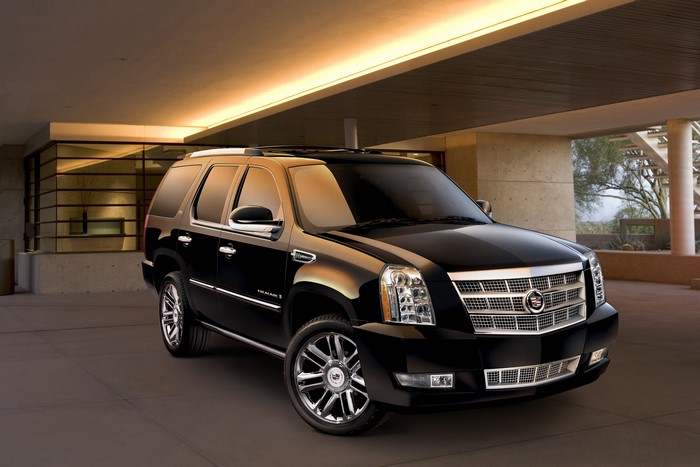 Black Cadillac Escalade ESV parked under a modern awning