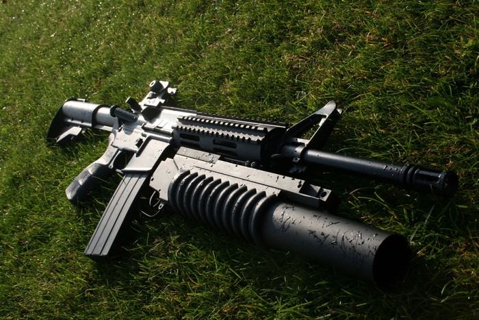 Assault rifle with grenade launcher on grass