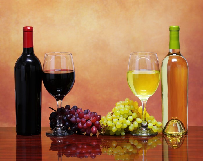 Red and White Wine Bottles with Grapes and Glasses