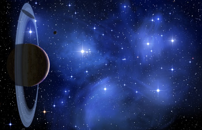 Planet with rings and moon in starry nebula