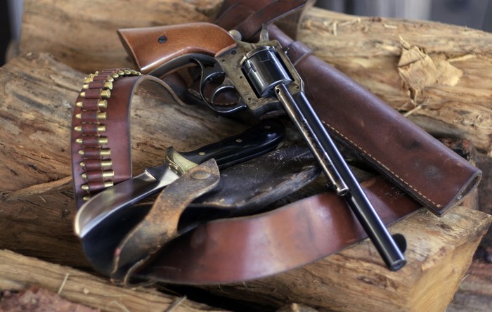 Revolver, Bullet Belt, and Knife on Wood