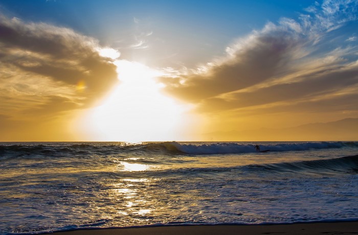 Surfer riding a wave at sunset in California