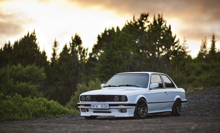 White BMW E30 325i parked on gravel road