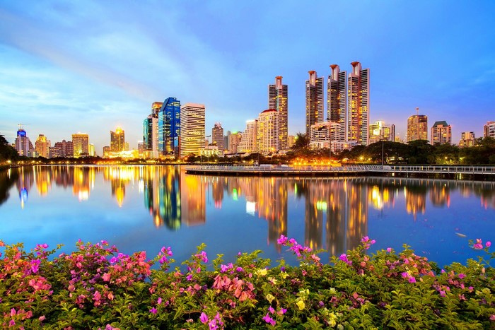 Cityscape with lake and flowers at dusk