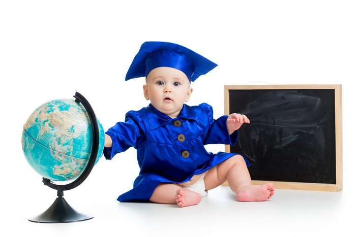 Baby in graduation cap and gown with globe and blackboard