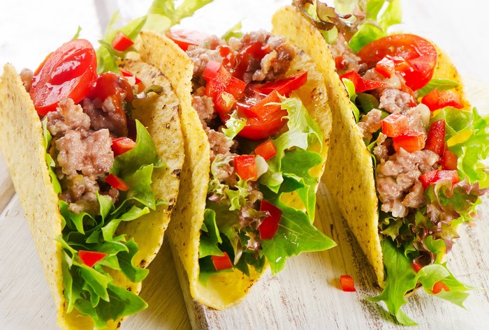 Tacos with ground meat, lettuce, tomatoes, and peppers