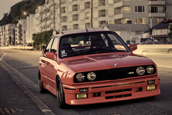 Red BMW M3 E30 parked on a street