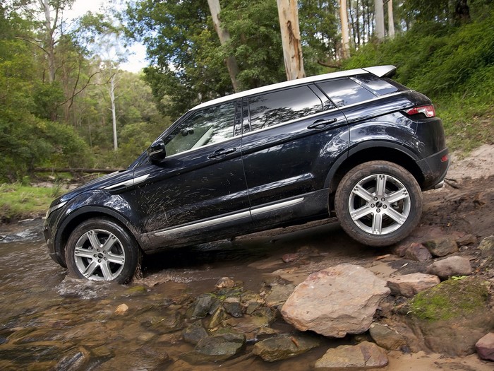 Black Land Rover Evoque driving through a stream