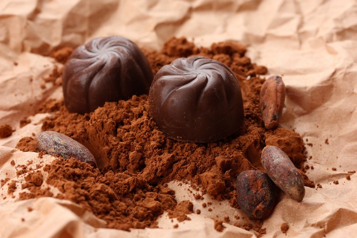 Chocolate candies with cocoa powder and beans
