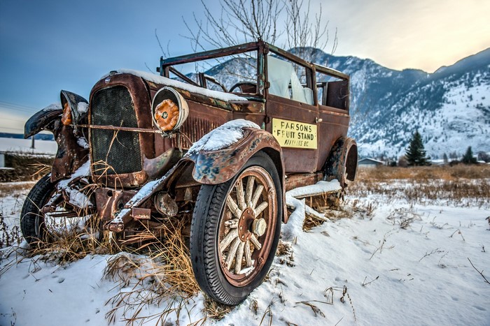 Abandoned vintage car with Parsons Fruit Stand sign in snow