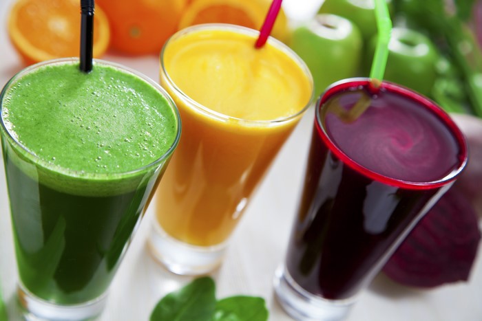 Three juices in glasses with fruits