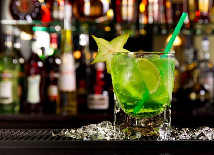 Green cocktail with starfruit and lime in a highball glass