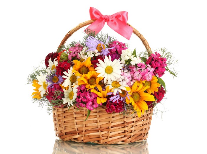Wicker basket with colorful flowers and pink bow