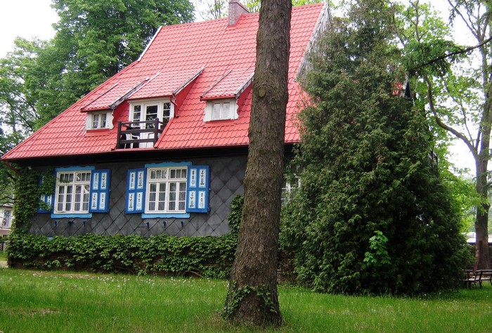 House with red roof and blue shutters in Poland