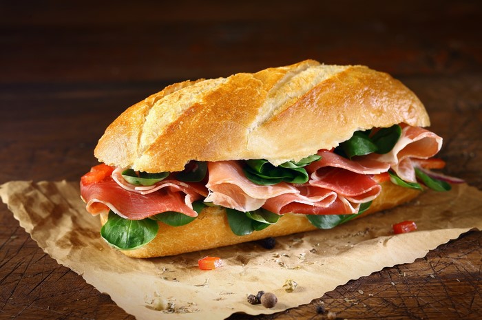 Sandwich with prosciutto and greens on a baguette