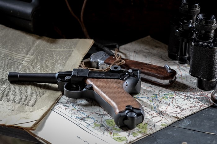 Luger P08 pistol on maps and newspaper