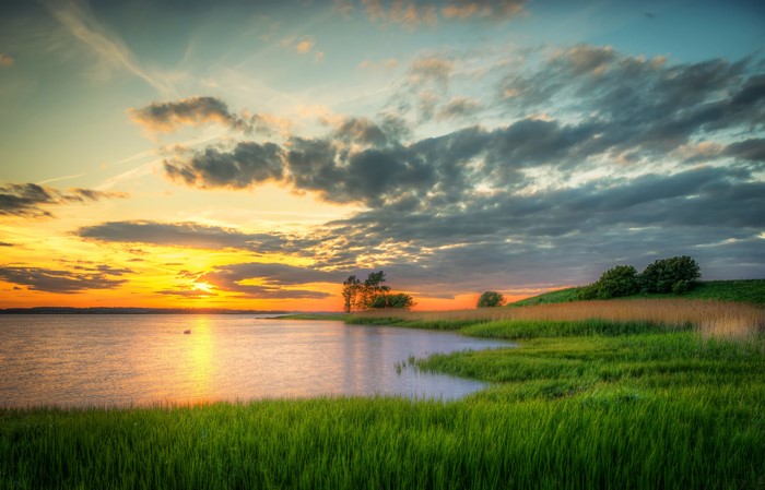 Sunset over a river with grassy banks in Germany