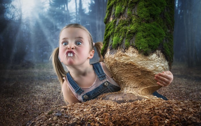 Girl making a funny face by a tree trunk