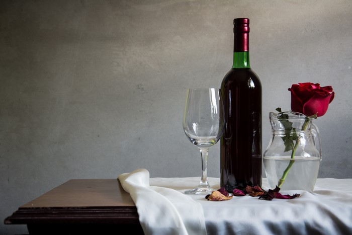 Still-life with wine bottle, glass, and rose