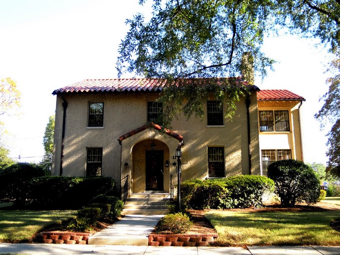 Spanish-style house with red tile roof and manicured lawn