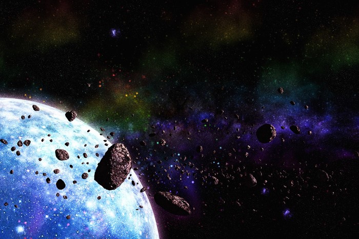 Asteroids orbiting a blue planet in a colorful nebula