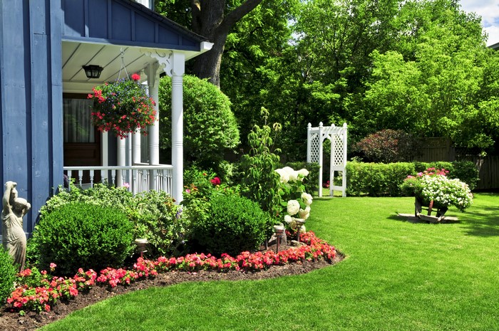Blue house with a porch and a manicured garden